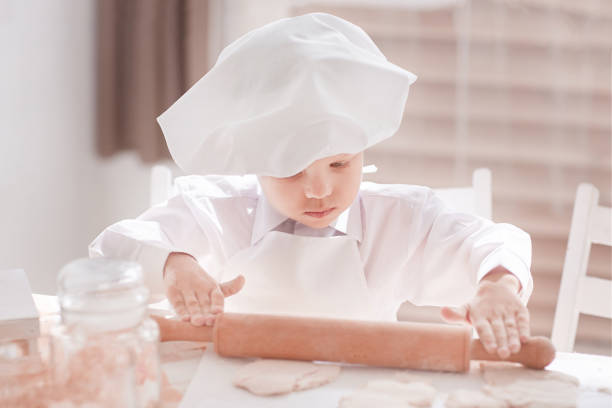 close up. boy cook rolling out the dough. the concept of a hobby