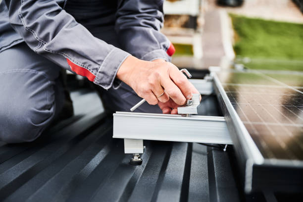 istock Close up view of professional engineer securing photovoltaic solar panel on a roof. 1473636428