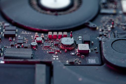 Close-up of a dirty laptop circuit board, microchips and other elements with a lot of dust