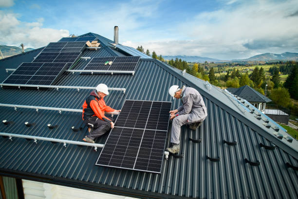 Men workers installing solar panels on roof of house. stock photo