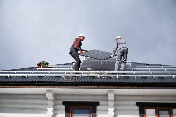 istock Technicians carrying photovoltaic solar module while installing solar panel system on roof of house 1473638822