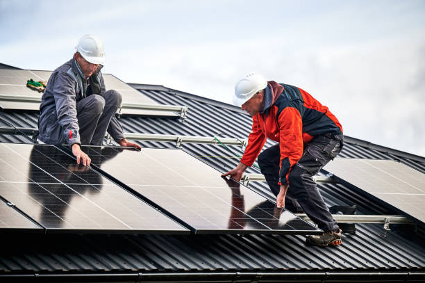 istock Men workers installing solar panels on roof of house. 1473638949