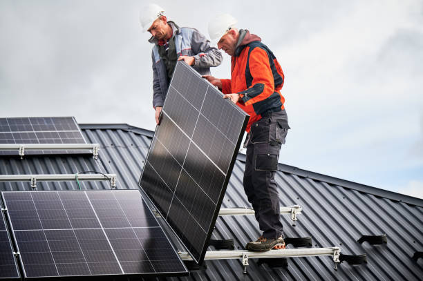istock Men workers installing solar panels on roof of house. 1473638956