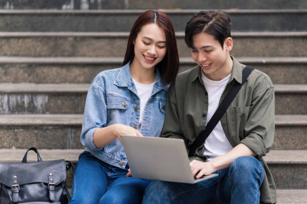 foto do casal asiático jovem ao ar livre - filipino ethnicity asian ethnicity women computer - fotografias e filmes do acervo