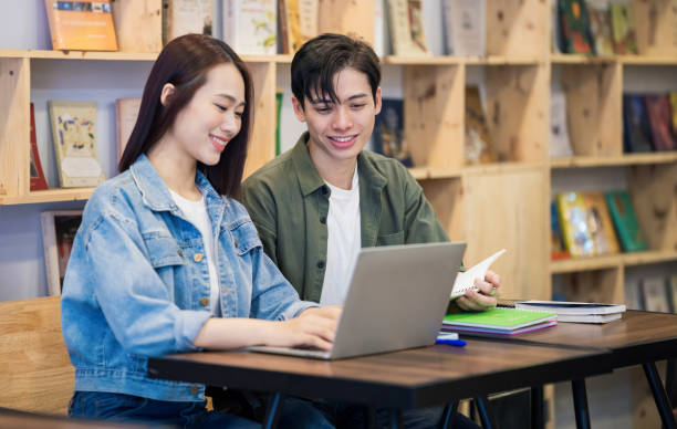 istock Young Asian couple studying at library 1473639536