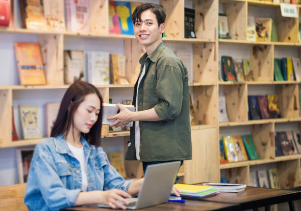 istock Young Asian couple studying at library 1473639545
