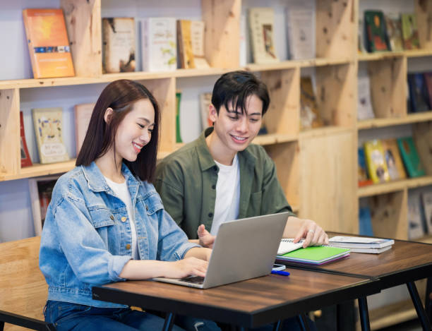 istock Young Asian couple studying at library 1473639546