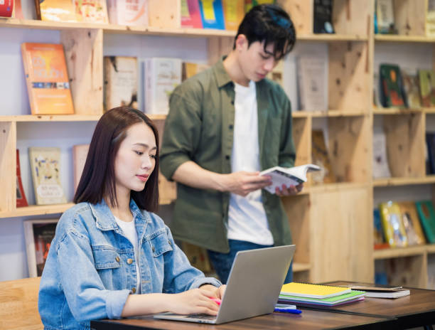 istock Young Asian couple studying at library 1473639549