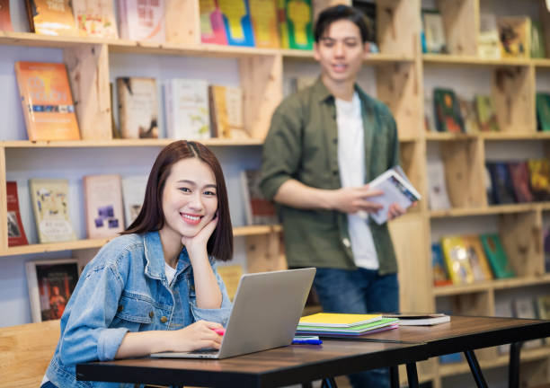 istock Young Asian couple studying at library 1473639554