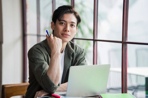 istock Young Asian businessman working at coffee shop 1473639564