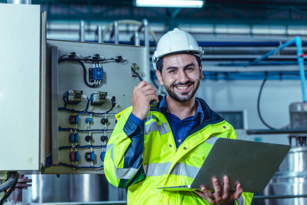 istock Portrait electricity worker hispanic engineer working in factory checking high voltage electrical power cabinet in factory. 1473640630
