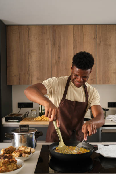 istock Young black man frying plantains slices. 1473641754