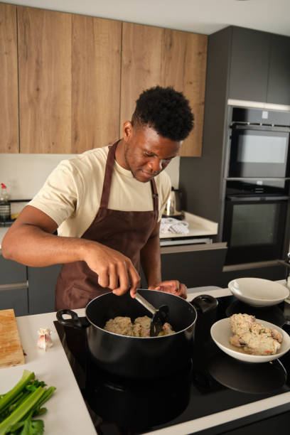 istock Young african man preparing fried chicken mince with vegetables recipe. 1473641772