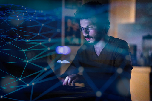 Young Computer Programmer Working On His Computer At Night With ...