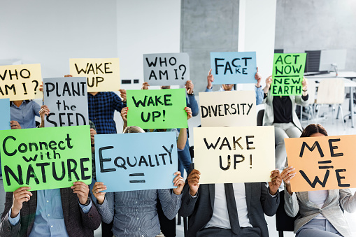 Large group of unrecognizable people holding banners with different messages on it.