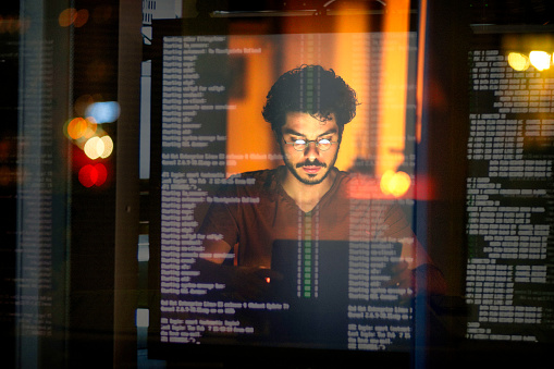 Young Computer Programmer Working On His Computer At Night With ...