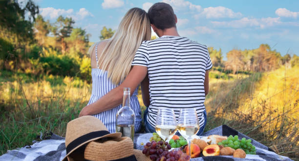 istock couple in love drinking wine on a picnic. Selective focus 1473643903