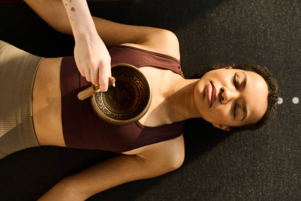 istock Woman meditating with singing bowl 1473645098