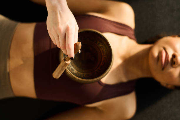 istock Woman using singing bowl in yoga practice 1473645104