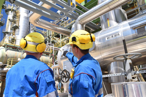 istock group of industrial workers in a refinery - oil processing equipment and machinery 1473647928