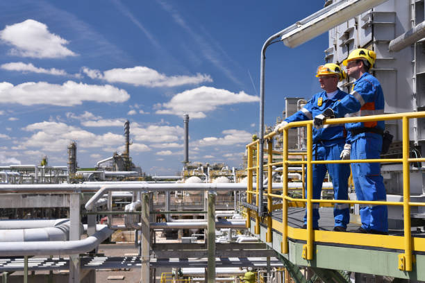 istock group of industrial workers in a refinery - oil processing equipment and machinery 1473648097