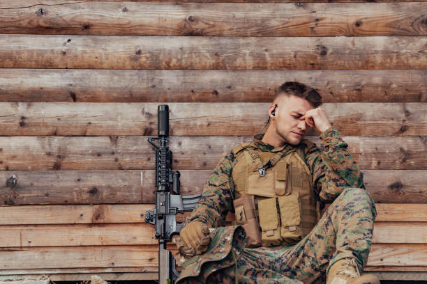 istock Upset soldier has psychological problems holding his head 1473648275