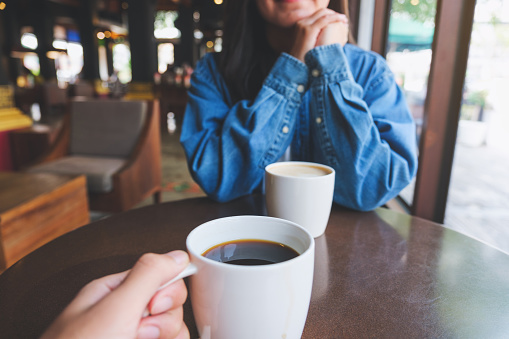 Closeup image of a young couple drinking coffee together while dating in cafe