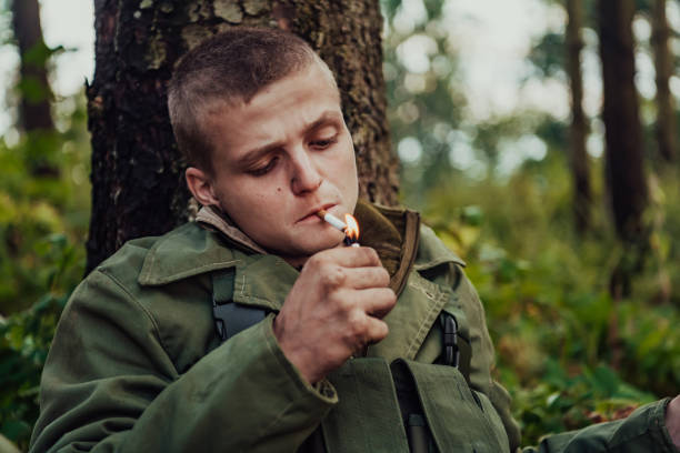 istock Terrorist have a break and smoke cigarette in forest during battle 1473651384