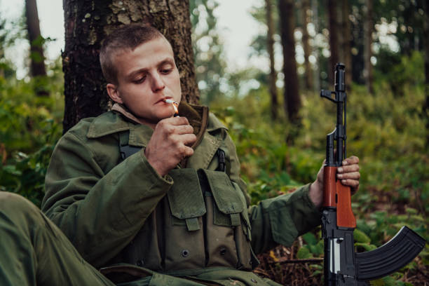 istock Terrorist have a break and smoke cigarette in forest during battle 1473651464