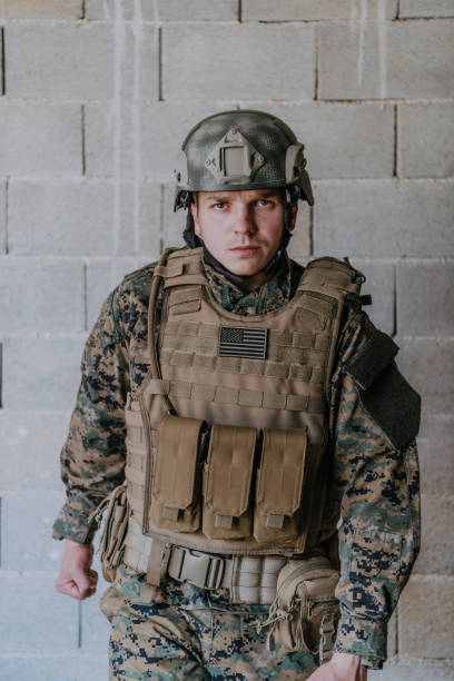 istock Soldier preparing tactical protective and communication gear for action battle 1473652374