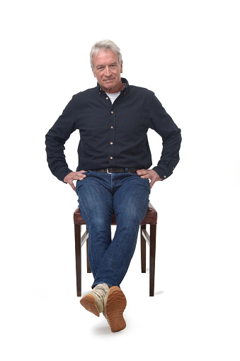 man sitting on a chair with arms akimbo on white background