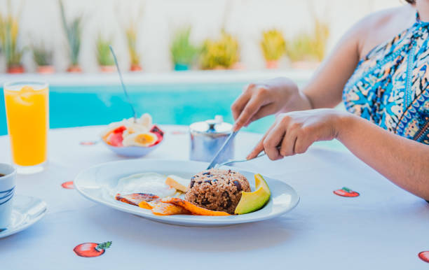 スイミングプールの近くで朝食。プールの近くで朝食をとる女の子の手 - serving food fruit salad human hand ストックフォトと画像