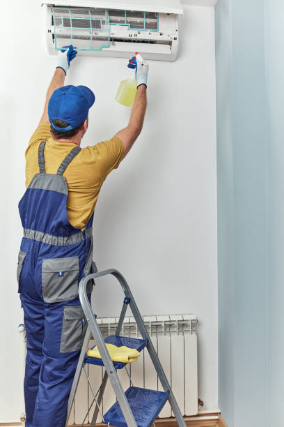 istock Repairman cleaning and fixing indoors AC unit. 1473655304