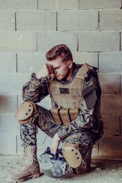 istock Upset soldier has psychological problems holding his head 1473656740