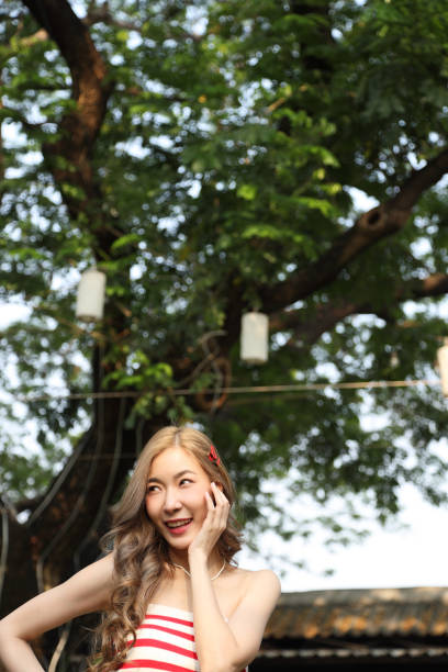 The cute Asian girl posing at the public park.