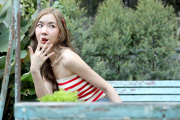 The cute Asian woman feeling relax posing in the outdoor restaurant.