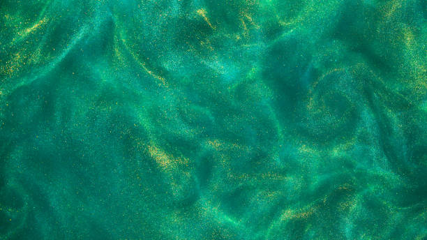 istock Magic gold dust over green background. Glow gold particle abstract background. 1473658553