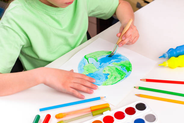 istock A child paints a globe with paint and a paintbrush. 1473659014