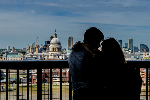 London, UK, July 17, 2017: The silhouette of a couple at the Tate Modern balcony is seen against London city-scape