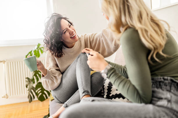 istock Two female friends sitting drinking coffee talking 1473660889