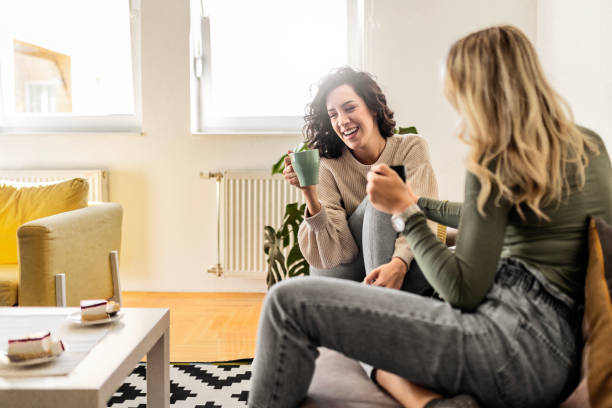 istock Two female friends sitting drinking coffee talking 1473660916
