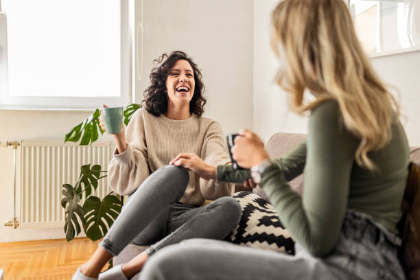 istock Two female friends sitting drinking coffee talking 1473660924