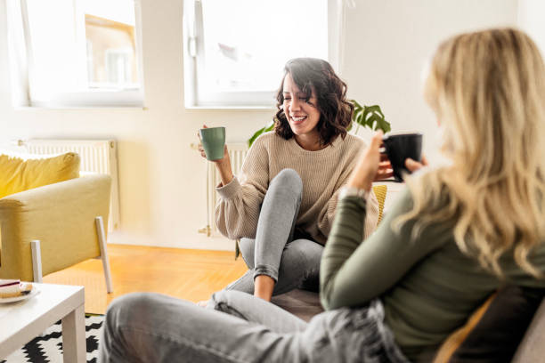 istock Two female friends sitting drinking coffee talking 1473660955