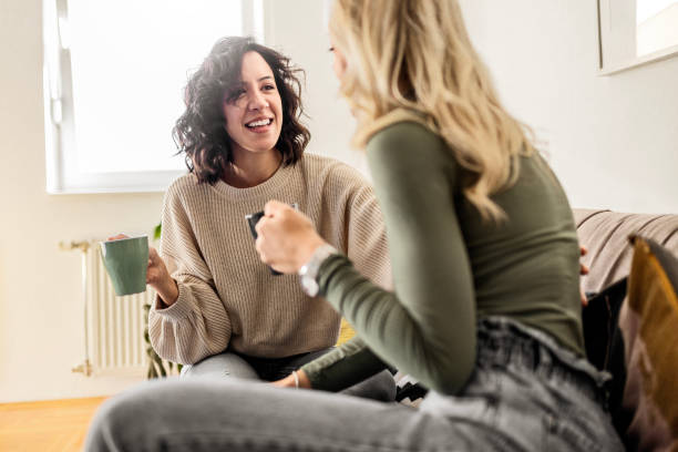 istock Two female friends sitting drinking coffee talking 1473660980