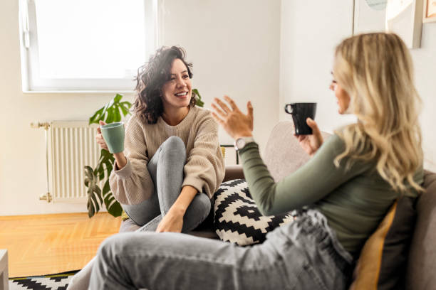 istock Two female friends sitting drinking coffee talking 1473660984