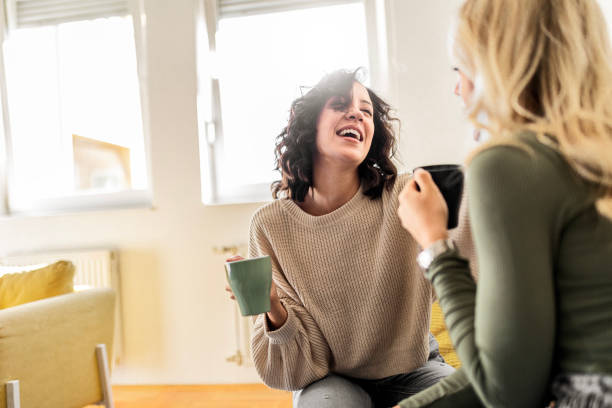 istock Two female friends sitting drinking coffee talking 1473660985