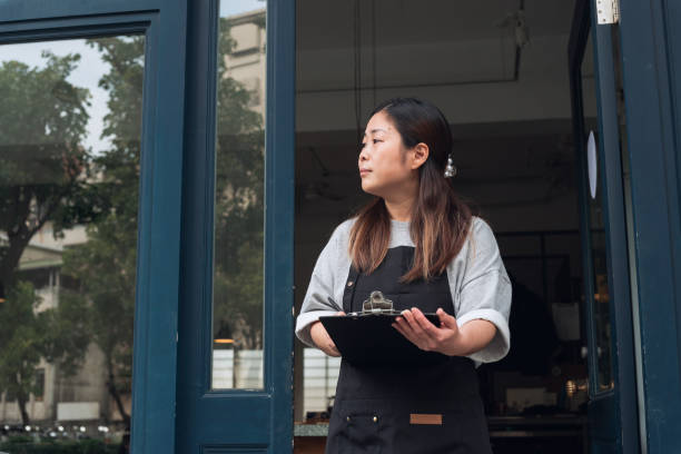 istock Coffee shop owner with Open sign 1473662071