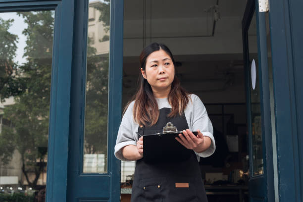 istock Coffee shop owner with Open sign 1473662152