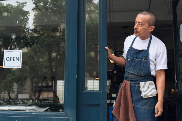 istock Coffee shop owner with Open sign 1473662168