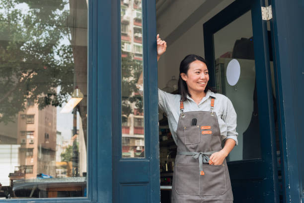 istock Coffee shop owner with Open sign 1473662201